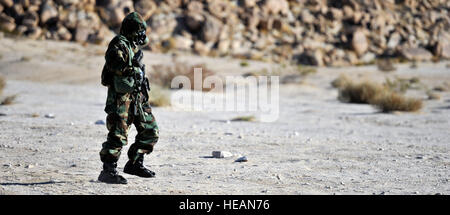 Stati Uniti Esercito privato di prima classe Henry Rios, un elemento di incendi del Tactical Command Post (TAC), 1° Battaglione, xv Reggimento di Fanteria, 3° Brigata pesante contro la squadra, terza divisione di fanteria, cerca il coperchio dopo aver assunto MOPP livello 4 durante il National Training Centre (NTC) iterazione 5-12, Fort Irwin, ca., Marzo 22, 2012. Questa iterazione NTC è stato il primo del suo genere in oltre dieci anni, l'apprendimento e la pratica di vigore il vigore battaglie utilizzando meccanizzato, suolo e aria beni. Il personale Sgt. Marco Saylock/rilasciato) Foto Stock