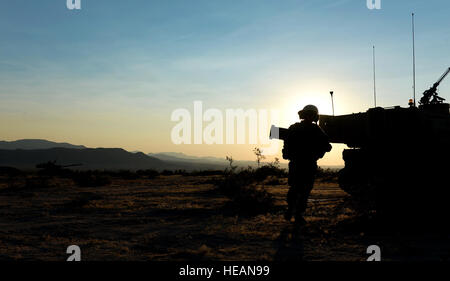 Un U.S. Soldato dell'esercito da Alfa batteria, 1° Battaglione, xli campo reggimento di artiglieria, porta attrezzature da un veicolo ad un altro durante un'azione decisiva 14-09 presso il Centro Nazionale di Allenamento qui, 7 Agosto, 2014. Azione decisiva rotazioni sono riflettenti delle complessità di avvisi di potenziali la nostra nazione potrebbero affrontare e includono: guerriglia ribelle, penale e di vicino-peer forze convenzionali tessuti in un ambiente dinamico. Senior Airman Daniel Hughes, 1a lottare contro lo squadrone della telecamera) Foto Stock