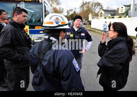 Membri del Maryland Task Force di una ricerca e salvataggio in aree urbane team parla con Melanie Pironti nella strada di fronte a casa sua in Oceanside, N.Y., nov. 4, 2012. Maryland TF 1 è una delle otto squadre attivato per essere una parte della nazionale di ricerca e salvataggio in aree urbane Task Force e stava conducendo di casa in casa a ricerche per coloro che necessitano di ulteriore assistenza. Il NS&R TF è operativo da base comuneGuire-Dix Mc-Lakehurst, N.J. Tech. Sgt. Parker Gyokeres Foto Stock