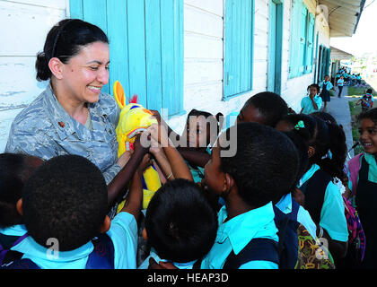 Stati Uniti Air Force Il Mag. Iris Ortiz González, periodontist da Offutt Air Force Base, Neb., detiene un cane giocattolo come Belizean bambini toccare i suoi denti durante una preparazione dentale esercizio presso San Pietro Claver Scuola in Punta Gorda, Belize, Aprile 25, 2013. Istruzioni per l'igiene orale sono stati forniti per Belizean bambini in tutta Punta Gorda per aiutare a stabilire prima infanzia abitudini dentale. I professionisti del settore dentale da parte degli Stati Uniti e il Canada sono fornire gratuitamente il trattamento dentale a più disponibilità di esercizi di formazione in tutto il Belize come parte di un esercizio noto come nuovi orizzonti. Le esercitazioni sono d Foto Stock