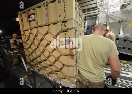 Stati Uniti Air Force aviatori assegnati alla 455th Expeditionary porta antenna squadrone lavorano insieme per spostare un pallet in avanti su una C-17 Globemaster III a Bagram Air Field, Afghanistan, 21 giugno 2014. Master Sgt. Cohen A. Giovani Foto Stock