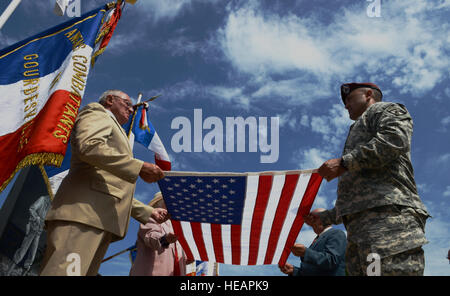 Locali francesi e degli Stati Uniti Soldati dal Fort Bragg Air Assault Scuola, N.C., piegare una bandiera degli Stati Uniti durante una cerimonia commemorativa per PFC. Charles DeGlopper, un paracadutista morto il D-Day durante la II Guerra Mondiale il 5 giugno 2015, Normandia, Francia. Più di 380 service membri provenienti da Europa e affiliati D-Day unità storiche partecipano al 71esimo anniversario come parte della Joint Task Force D-Day 71. La task force, con sede in Saint Mere Eglise, Francia, è il supporto di eventi locali attraverso la Normandia, da giugno 2-8, 2015, per commemorare il generoso delle azioni da parte di tutti gli alleati sul D-Day che continuano a reson Foto Stock