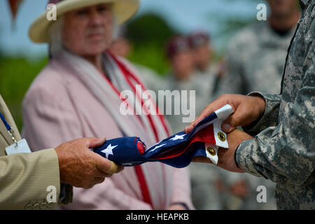 Locali francesi e degli Stati Uniti Soldati dal Fort Bragg Air Assault Scuola, N.C., piegare una bandiera degli Stati Uniti durante una cerimonia commemorativa per PFC. Charles DeGlopper, un paracadutista morto il D-Day durante la II Guerra Mondiale il 5 giugno 2015, Normandia, Francia. Più di 380 service membri provenienti da Europa e affiliati D-Day unità storiche partecipano al 71esimo anniversario come parte della Joint Task Force D-Day 71. La task force, con sede in Saint Mere Eglise, Francia, è il supporto di eventi locali attraverso la Normandia, da giugno 2-8, 2015, per commemorare il generoso delle azioni da parte di tutti gli alleati sul D-Day che continuano a reson Foto Stock