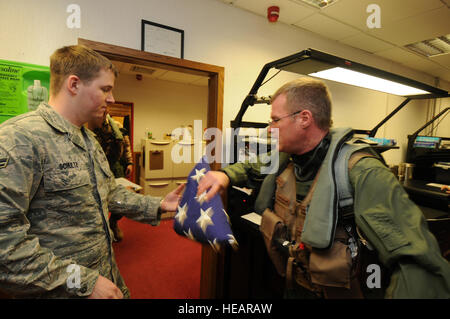 SPANGDAHLEM AIR BASE, Germania - Lt. Col. Paul Murray, 480th Fighter Squadron commander, prende una bandiera americana da Airman 1. Classe Jordon Schultz, 52nd operazione il supporto Squadron, qui per essere volato mentre il supporto di operazione Odyssey Dawn Marzo 19. Joint Task Force Odyssey Dawn è la U.S. Africa il comando task force istituita per fornire comando operativo e tattico e di controllo le forze militari USA a sostegno della risposta internazionale per i disordini in Libia e in applicazione della risoluzione del Consiglio di Sicurezza delle Nazioni Unite (UNSCR) 1973. La UNSCR 1973 autorizza tutte le misure necessarie per protec Foto Stock