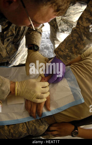 Stati Uniti Army Spc. Nathan Patterson del Delta Company, 2° Battaglione, 8 Cavalleria, 1° Brigata Team di combattimento, 1° Divisione di cavalleria, fornisce cure mediche a un compagno soldato in Taji, Iraq, Sett. 17. Foto Stock