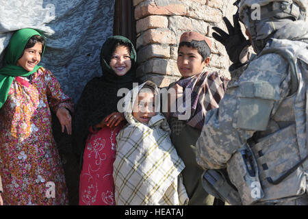 Stati Uniti Army Spc. Sydaless Watson, nativo di Killeen, Texas e un soldato di alimentazione con la 97th Polizia Militare Battaglione fuori di Fort Riley, Kan., fa una faccia buffa per bambini afgani in Rajan Qala Village di Arghandab River Valley. I soldati della 97th MP Bn. stavano aiutando Polizia nazionale afgana e forze canadesi con funzionamento Fazilat gen. 10. : Staff Sgt. Christine Jones) Foto Stock