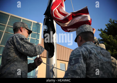 Osan onore guardie sollevare l'Americano e un prigioniero di guerra/mancante in azione le bandiere durante una cerimonia di sveglia per il kick off POW/la mia settimana a Osan Air Base, Repubblica di Corea, Sett. 17, 2013. Un atto di congresso nazionale stabilito POW/mia giornata di riconoscimento dal passaggio della sezione 1082 del 1998 Difesa atto di autorizzazione. Il personale Sgt. Sara Csurilla) Foto Stock