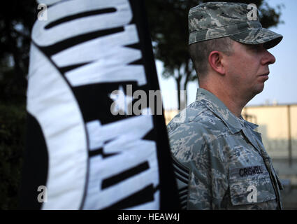 Il personale della U.S. Air Force sta accanto alla bandiera POW/mia durante una cerimonia di ritiro presso la base aerea di Osan, Repubblica di Corea, il 18 settembre 2013, in osservanza del National POW/mia Recognition Day in onore dei prigionieri di guerra e del personale scomparso. Foto Stock