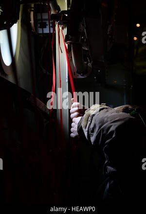 Un U.S. Air Force commando di aria dal 321Tattiche speciali Squadron afferra un cinturino per il sedile a gambo di un MC-130J Commando ll assegnato a RAF Mildenhall, in Inghilterra il 27 febbraio 2015, vicino a Sculthorpe, Inghilterra. La 321STS aviatori sono addestrati per recuperare feriti o abbattuti in personale ad alto rischio o posizioni di austera. Senior Airman Victoria H. Taylor Foto Stock