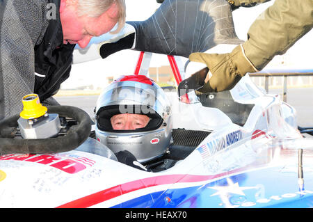 RAF MILDENHALL, Inghilterra - racing legend Mario Andretti, vincitore del 12 Formula 1 Grand Prixs, secondo posto in tutti i tempi e di vittorie di tutti i tempi la pole position vincitore in IndyCar racing, siede pazientemente in biposto IndyCar come le regolazioni finali e controlli sono apportate alla vettura prima che egli lo spinge verso il basso la Flightline qui a gennaio 21, 2011. Elementi di base di entrambe le foto in RAF Mildenhall e Lakenheath si alternarono nel sedile del passeggero della vettura, e raggiungere una velocità di fino a 150 mph come Andretti, lungo con driver britannico Martin Plowman, un Indy Lights racing driver, diede loro il brivido di una vita. Karen Abeya Foto Stock