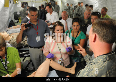 Lt. Col. David Nelson, Chirurgo di volo con la 133Medical Group, Minnesota Air National Guard, utilizza un simulatore di parto manichino per dimostrare il bambino nelle procedure di consegna ai visitatori touring una tenda EMEDS Patriot durante l'esercizio 2013 al campo Volk, Wis., luglio 17, 2013. Campo Volk ha riunito le unità militari e agenzie civili provenienti da tutta la nazione per affinare la loro domestica le capacità di risposta a Patriot esercizi per diversi anni. (Brevetto statunitense n. S. Senior Master Sgt. Paolo Mann Foto Stock