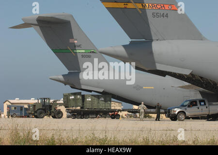 Stati Uniti Air Force aviatori cargo carico su due C-17 Globemaster III aeromobili a navi ausiliarie campo di atterraggio San Clemente, California, 17 aprile nel supporto del gancio Patriot 2011. Patriot gancio è un annuale Air Force Reserve Tanker Airlift elemento di comando esercizio di simulazione di una forza comune risposta alle catastrofi naturali in avanti di una posizione dispiegata. L'esercizio distribuisce tre unità TALCE e riunisce le unità della Air Force, riserva marina, Department of Homeland Security e di altre agenzie federali per la pratica del carico la pianificazione e le procedure di manipolazione. Foto Stock