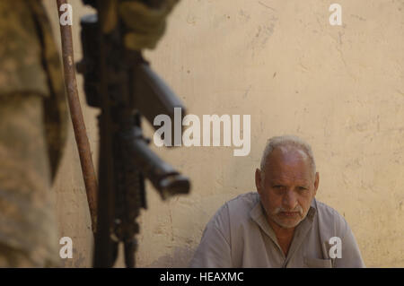 Stati Uniti Army Spc. Angelo, un linguista con Delta Company, 1° Divisione di cavalleria, dodicesimo Reggimento di Fanteria, veglia su di un uomo come soldati cerca la sua casa a Khalis, Iraq, nel febbraio 21, 2007. Master Sgt. Andy Dunaway) (rilasciato) Foto Stock