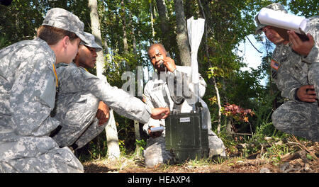 Sgt. 1. Classe Delroy Barnet (centro), che rappresenta la trentaduesima brigata medica a base comune San Antonio-Fort Sam Houston, report di intelligence dopo il montaggio di una radio manpack durante il 2012 Advanced Training individuale sergente di plotone dell'anno di competizione a Fort Eustis, Virginia, Sett. 25. Foto Stock