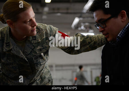 Air Force Capt. Danielle Shubert, 673d operazioni mediche Squadron pediatrico infermiera clinica, tende a Airman Garrett Hilde, 732nd Aria Mobilità Squadron passenger service agent, dopo aver mostrato i sintomi di un "attacco d'asma' durante l'esercizio forza polare 14-1 noncombatant operazioni di evacuazione, Feb. 5,2014 a base comune Elmendorf-Richardson, Alaska. Garrett ha giocato un NEO evacuee durante l'esercizio. Il fuoco primario di un NEO è progettato per spostare rapidamente i cittadini statunitensi da una regione pericolosa per un rifugio sicuro o suolo americano. Il personale Sgt. Sheila deVera) Foto Stock