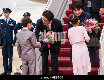 Primo Ministro del Giappone Shinzō Abe e Akie Abe salutare e ricevere fiori da Glenn Vamvalnburg, Great Falls Scuola Elementare Japanese-American seconda-grader, e Megan Dooley, quarto grado Japanese-American e Junior ginnasta olimpionica, a base comune Andrews, Md., 27 aprile 2015. Abe è negli Stati Uniti per un giro visita a promuovere più forte militare e i legami economici. Senior Master Sgt. Kevin Wallace Foto Stock