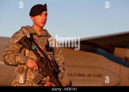 Airman 1. Classe Abdiel Rivera passeggiate lungo il perimetro di una C-130J Hercules, nov. 19, 2014. Il velivolo è da 146Airlift Wing basato sulle Isole del Canale Air National Guard Base, Oxnard in California Rivera è una delle forze di sicurezza specialista della New Jersey Air National Guard 177th della forze di sicurezza Squadron. (U.S. Air National Guard photo/Tech. Sgt. Matt Hecht) Foto Stock