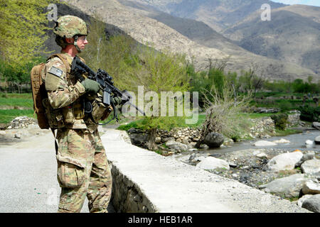 Stati Uniti Esercito nazionale Guard Spc. Joshua Jacobs, nativo di Austin, Texas, esegue la scansione della linea di colmo del vicine montagne durante una visita ai locali per la costruzione di strade, 31 marzo. Jacobs è parte della forza di sicurezza elemento per il Team di Ricostruzione Provinciale Kunar ed è distribuito dalla società alfa, 1° Battaglione, 143Fanteria (Airborne) fuori di Austin, Texas. Foto Stock