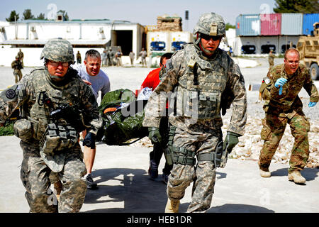 I membri del Team di Ricostruzione Provinciale Zabul e Zabul agro-alimentare del team di sviluppo di trasportare un ferito civili locali a UH-60 Black Hawk in avanti su una base operativa Smart, Afghanistan, e il Agosto 5, 2011. PRT Zabul assiste il Zabul Ospedale Provinciale per trattare o medicalmente evacuare criticamente pazienti feriti al fine di salvare la loro vita. Foto Stock