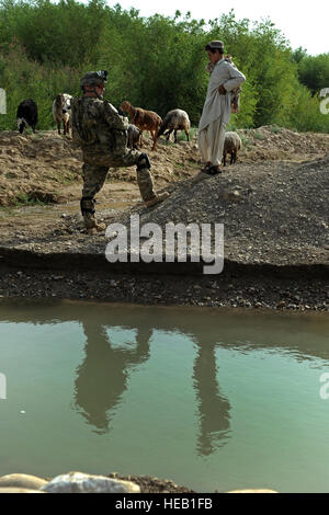 Stati Uniti Esercito Capt. Daniel-Simon Leonard, operations officer, parla con un ragazzo locale presso il fiume Tarnek in Qalat City, Afghanistan, 9 luglio. Leonard è un membro del Team di Ricostruzione Provinciale Zabul. PRT Zabul è compreso di Air Force, esercito, il Dipartimento di Stato degli Stati Uniti, Agenzia per lo Sviluppo Internazionale di Agricoltura e U.S. Esercito di ingegnere il personale che lavora con il governo dell'Afghanistan per migliorare la governance, la stabilità e lo sviluppo di tutta la provincia. Foto Stock