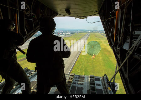 (Da sinistra a destra) Airman 1. Classe Andrew Fox e Tech. Sgt. Todd Bergin, loadmasters assegnato alla XXXVI Airlift Squadron, distribuire a basso costo e bassa altitudine payload durante una settimana di preparazione alla missione di formazione su Yokota Air Base, Giappone, Ottobre 8, 2013. Settimana di preparazione si concentra su Yokota professionale della missione di trasporto aereo e gli avieri in via di sviluppo la possibilità di supportare ogni contingenza nel Pacifico. Osakabe Yasuo Foto Stock