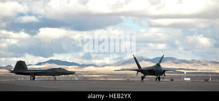 Due F-22 Raptors taxi per la pista durante la bandiera rossa 15-1 Gen 27, 2015, presso la Base Aerea Militare di Nellis Nev. Bandiera rossa è una di una serie di corsi di formazione avanzati programmi gestiti da parte del governo degli STATI UNITI Air Force Warfare Center, progettato per aumentare la prontezza di combattimento e di efficacia. F-22s sono assegnati alla 94th Fighter Squadron da base comune Langley-Eustis, Va. Senior Airman Thomas Spangler) Foto Stock