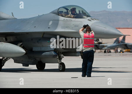 Il personale Sgt. Nathaniel Hall, 55th Fighter Squadron dedicato capo equipaggio, segnali per un pilota durante la fase di pre-flight controlli prima di una bandiera rossa 15-3 sortie presso la Base Aerea Militare di Nellis Nev., 13 luglio 2015. Red Flag è condotta sulla prova di Nevada e campo di addestramento e comporta degli Stati Uniti e delle forze alleate provenienti da tutti i rami del servizio. Foto Stock