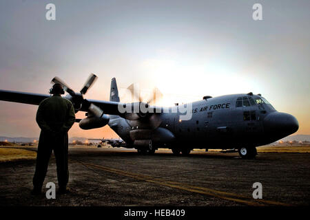 YOKOTA AIR BASE, Giappone -- Il personale Sgt. Charles Kirchen, 36th Airlift Squadron, orologi come i motori avviamento su un C-130H Hercules Marzo 19 prima di una missione. Materiali di consumo medicali sono volato a Sendai e Hanamaki Airport per essere distribuito agli ospedali locali e centri di evacuazione come parte di Operazione Tomodachi. Il personale Sgt. Jonathan Steffen) Foto Stock