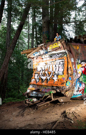 Il treno relitto trail. Il naufragare box cars lasciati da un 1950 PGE deragliamento ferroviario, ora un posto popolare per i locali artisti di graffiti. Foto Stock