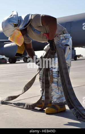 Senior Airman Jermaine Arzu, un capo equipaggio assegnati a 380° Expeditionary ingegnere civile Squadron qui, carichi di un triplo strato handline torna nel vano del suo carrello per aiutare a ottenere il carrello torna in servizio dopo un esercizio di formazione qui dic. 10, 2013. Arzu è originariamente da Los Angeles, California, e distribuito qui da Davis-Monthan Air Force Base, Ariz. Master Sgt. Aprile LapetodaA pompiere, chi è assegnato al 380 Expeditionary ingegnere civile Squadron qui, porta un manichino di formazione per i tecnici medicali da 380° Gruppo medico che sono esecuzione del triage su un altro treno Foto Stock