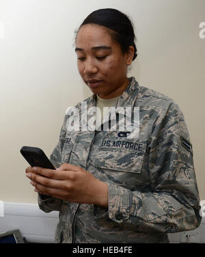 Stati Uniti Air Force Airman 1. Classe Tynisha Spencer, centesimo disponibilità logistica squadrone di gestione del traffico artigiano da Fairfield, California, mostra come è facile comporre un numero con il nuovo DUI prevenzione applicazione il 9 aprile 2015, sulla RAF Mildenhall, Inghilterra. Il nuovo DUI prevenzione applicazione consente agli utenti di chiamare gli avieri contro la guida in stato di ebbrezza, potete prendere un taxi o un supervisore con il semplice tocco di un pulsante. Gina Randall Foto Stock