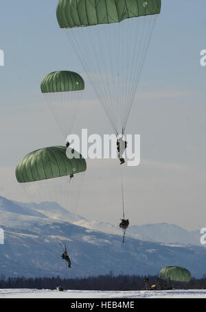 I soldati assegnati a U.S. Esercito dell Alaska 425th brigata truppe speciali battaglione catapultato un Humvee sulla JBER's malamute nella zona di caduta, seguita da circa 60 paracadutisti da una C-17 velivoli, Aprile 17, 2013. I paracadutisti della quarta brigata Combat Team (Airborne) xxv divisione di fanteria ha recentemente completato il post-distribuzione, reset e stanno passando la brigata di assumere una parte della rapida reazione vigore missione per il Teatro pacifico. Justin Connaher) Foto Stock