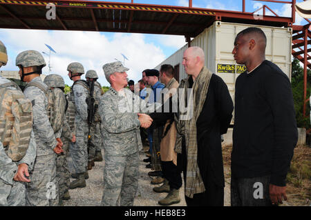 Gen. Herbert 'Hawk' Carlisle, Pacific Air Forces commander, scuote le mani con Master Sgt. Giuseppe Crow, 736th delle forze di sicurezza lo squadrone di normalizzazione e di valutazione sottufficiale in carica, dopo un contatore-improvvisato dispositivo esplosivo dimostrazione di formazione in campo di nord-ovest, Guam, Dicembre 3, 2012. Avieri dal 736th SFS indossato la loro marcia mentre altri vestito come forze contrarie al presente il generale con differenti capacità di formazione che Andersen Air Force Base offre per la regione Asia Pacifico. Airman 1. Classe Marianique Santos Foto Stock