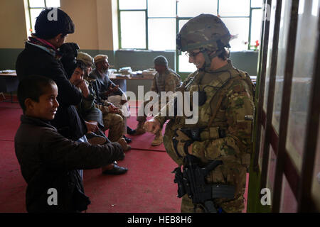 Il personale Sgt. Elizabeth Rosato, 755th Expeditionary forze di sicurezza Squadron Reaper Team 1 stati, risponde con locale bambini afgani al di fuori di Bagram Air Field, Afghanistan, Marzo 11, 2013. Il Mietitore team conduce le pattuglie nei pressi di Bagram Air Field contatore di ordigni esplosivi artigianali e indiretta di attacchi di fuoco nonché per impegnare locali' supporto nella protezione di base. Senior Airman Chris Willis) Foto Stock