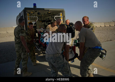 (Sinistra) Tech. Sgts. Johua Sevilla e Raymond Jones, 76th manutenzione aeromobili, unità di Camp Bastion Afghanistan, aiutano i membri della Royal Air Force Critical Care Air Support Team scaricare un ferito nazionale afghano di forza di sicurezza gli stati da un'ambulanza. L'equipaggio e quindi viene caricata su di lui un U.S. Air Force HC-130P Hercules in ordine per il trasporto del paziente ad un impianto di trattamento medico durante un trasporto di medicina aeronautica la missione. La HC-130P Hercules è assegnato alla 76th Expeditionary squadrone di soccorso che è responsabile per la conduzione di lottare contro la ricerca e soccorso e così come il personale delle missioni di recupero ho Foto Stock