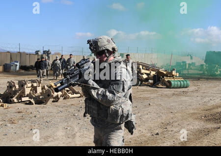 Stati Uniti Esercito privato classe 1Brett operaio, un Co., 1° Battaglione, 501Reggimento di Fanteria, quarta brigata Combat Team (airborne), XXV divisione di fanteria, dimostra come reagire al nemico contatto alla frontiera afgana la polizia gli studenti a inoltrare una base operativa Waza Khwa, Dic 15, 2009.L'ABP studenti partecipano a un 3 settimana di sviluppo della leadership corso dove essi sono apprendere e mettere in pratica le abilità di combattimento e tecniche di leadership. ( Staff Sgt. Dallas Edwards Foto Stock