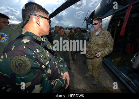 Stati Uniti Air Force Master Sgt. Giovanni La Medcalf, destra, xxxiii Rescue Squadron missioni speciali aviatore, mostra Philippine Air Force equipaggi di aeromobili ,50 munizioni calibro al fianco di un componente RQS HH-60G Pave Hawk elicottero durante uno scambio bilaterale come parte di esercizio Balikatan 2015 in Clark Air Base, Filippine, 22 aprile. Il cambio ha dato il servizio degli Stati Uniti ai membri la possibilità di interagire con i membri del PAF e rafforzare Philippine-U.S. piccole unità Relazioni con i leader. (U.S. Air Force photo by Staff Sgt. Maeson L. Ellemann) Foto Stock