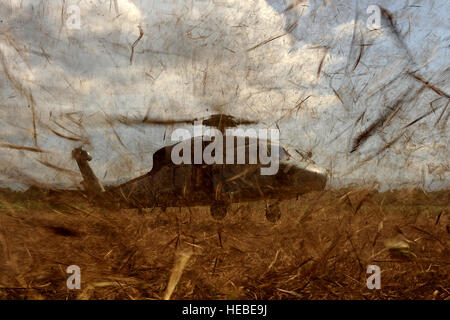 Un U.S. Navy HH-60 si prepara a terra in un campo e pick up U.S. Air Force Combat Controller e U.S. Esercito esploratori conducendo una zona di caduta di indagine per la futura caduta aria siti su gennaio 24, 2010 a Port-au-Prince, Haiti durante il funzionamento risposta unitaria. (U.S. Air Force foto di Master Sgt. Jeremy Lock) (rilasciato) Foto Stock