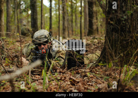 Un U.S. Esercito Black Hawk capo equipaggio assegnati alla 82a combattere la Brigata Aerea, guarda attraverso i siti di ferro di un M249 fucile automatico nov. 5, 2015, a Fort Polk, La. il soldato ha preso parte a una formazione di sopravvivenza esercizio con Air Force e l'esercito personale di volo dopo una simulazione di crash dietro le linee nemiche. (U.S. Air Force foto di Senior Airman Harry Brexel) Foto Stock