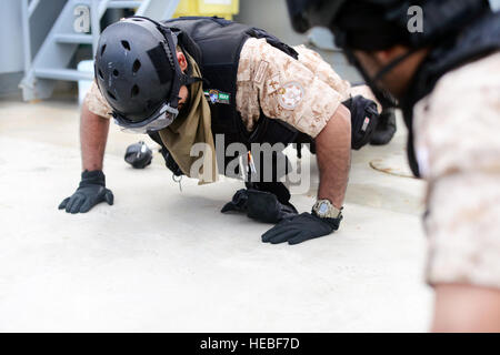 Kuwaitiana militari membri eseguire push-up a bordo della U.S. Recipiente di esercito di "Corinto" per il warm-up prima di iniziare la visita, scheda, ricerca e formazione di grippaggio durante l'esercizio Eagle risolvere Marzo 17, 2015. Esercizio Eagle risolvere 2015 offre 29 nazioni partner la possibilità di allenarsi insieme per affrontare le sfide regionali associato/asimmetrica la guerra non convenzionale in un multi-nazionale per l'ambiente. Questo è il governo del Kuwait la prima volta di aquila hosting risolvere, che è la premiere Penisola Arabica/Regione del Golfo esercizio tra gli Stati Uniti, il Consiglio di cooperazione del Golfo nazioni e ot Foto Stock