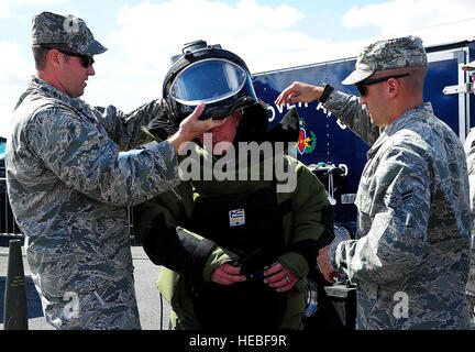 Il cap. John Pickering, 436th ingegnere civile squadrone ordinanza sugli esplosivi smaltimento comandante di volo e Airman 1. Classe Andrew Vitale, 436th CES EOD apprendista, aiuto Frank Rusek messo su bomb squad suit sett. 29, 2013, a Dover International Speedway di Dover, Del. la bomb squad volontariamente durante il weekend di gara per dimostrare le loro capacità al pubblico. (U.S. Air Force foto/Airman 1. Classe Ashlin Federico) Foto Stock