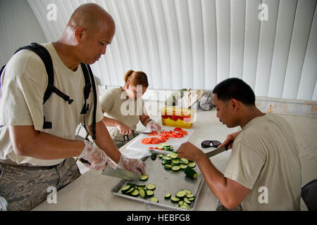 Stati Uniti Air Force Staff Sgt. Cesar Contreras, sinistra, Senior Airman Learsi Canosa, 940th forza squadrone di supporto, Beale AFB, in California, e Airman Joyce Ayson, 446th forza squadrone di supporto, McChord AFB, nello Stato di Washington, preparare insalata per cena durante il Global Medic 2013, Fort McCoy, Wis., 16 luglio 2013. Global Medic è un misto annuale-campo di riserva-esercizio progettata per replicare tutte le sfaccettature del teatro di combattimento di medicina aeronautica supporto di evacuazione. (U.S. Air Force photo by Staff Sgt. Heather Cozad/rilasciato) Foto Stock