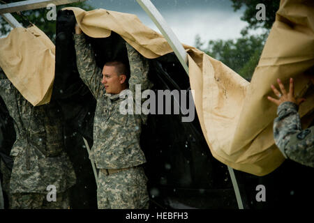 Un U.S. Army Spc. Eric Bruce, 901st un minimo di cura di distacco, Fairmont, W. Va., assembla una strutture Alaska tenda a sostegno dell'esercizio Global Medic, Fort McCoy, Wis., luglio 21, 2013. Global Medic, in congiunzione con WAREX, è un misto annuale-campo di riserva-esercizio progettata per replicare tutte le sfaccettature del teatro di combattimento di medicina aeronautica supporto di evacuazione. (U.S. Air Force photo by Staff Sgt. Heather Cozad/rilasciato) Foto Stock