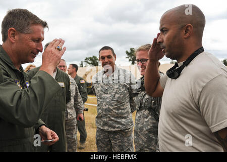 Stati Uniti Air Force Brig. Gen. Derek P. Rydholm, direttore, ARIA, spazio e operazioni di informazione, Air Force comando Reserve, Robins Air Force Base, Ga., monete Senior Airman Steven campi con la trentaseiesima edizione di medicina aeronautica squadrone di evacuazione, Papa Campo, N.C., durante la sua visita a Fort McCoy, Wis., 27 luglio 2013. Gen. Rydholm sta visitando gli avieri, soldati e marinai che effettuano la formazione medica durante il guerriero esercizio 86-13-01 (WAREX)/esercizio Global Medic 2013. WAREX unità fornisce un opportunità di provare le manovre militari e tattiche. Si è svolto in concomitanza con WAREX, Global Medic è un misto annuale- Foto Stock