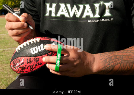 Una Università delle Hawaii football player firma un autografo per gli spettatori dopo un mese di agosto 16 guerrieri pratica al Campo Earhart, Base comune Harbor-Hickam perla, Hawaii. Il team ha vissuto e ha lavorato sul campo Hickam da Agosto 13-17 a causa del UH dormitori essendo puliti e preparati per l'avvio della sessione di autunno. I Guerrieri sono pianificate per essere sulla strada per la loro opener sett. 1, a Los Angeles, contro la University of Southern California Trojan. Hazlewood è assegnato al quindicesimo gruppo medico, Hickam campo. Foto Stock