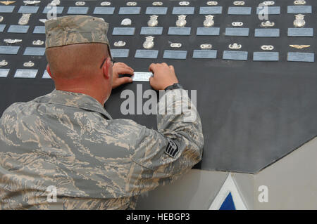 Il personale Sgt. Karl ferree, un artigiano strutturali assegnati per la 332Expeditionary ingegnere civile Squadron, posizioni delle placche che elenca i nomi di Tech. Sgt. Anthony Capra e il personale Sgts. Christopher Frost e Travis Griffin qui, Apr. 16. I tre aviatori che hanno perso la vita durante le operazioni in Iraq durante gli ultimi sei settimane. I nomi e i badge di aviatori che sono morti durante la guerra globale al terrorismo sono visualizzati sul Airman Memorial Al Balad Air Base per servire come un promemoria di quelli che hanno pagato il prezzo estremo per l'America la libertà e la sicurezza. Ferree è distribuito da Luca Air Forc Foto Stock