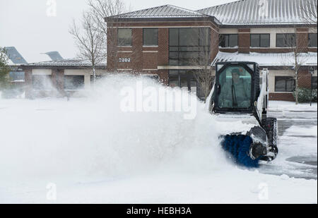 Un 87th ingegnere civile Squadron Airman cancella la neve da un parcheggio su base comuneGuire-Dix Mc-Lakehurst, N.J., Gennaio 27, 2015. La 87th CES i membri hanno lavorato per 12 ore di lavoro per preparare e poi pulire dopo la tempesta di neve Juno. (U.S. Air Force foto di Airman 1. Classe Joshua D. RE/rilasciato) Foto Stock