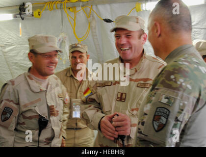 Lt. Col. Gheorghe Ionascu (centro), vice comandante della gendarmeria rumena condizionato a Spin Boldak condivide un ridere con il Brig. Gen. Guy Cosentino, nato Training Mission-Afghanistan Vice comandante, a giugno 16, 2011, provincia di Kandahar, Afghanistan. La Gendarmeria rumena ha cominciato a fornire consulenza Polizia nazionale afgana dei formatori in Afghanistan in aprile 2011. (U.S. Air Force foto di Tech Sgt. Adrienne Brammer) Foto Stock