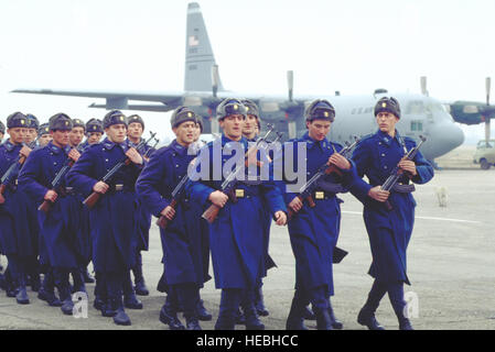 In Otopeni Air Base, Bucarest, Romania, Rumeno aviatori marzo off dopo il giuramento di reclutamento in occasione della cerimonia. In fondo è il C-130 dalla 37th Airlift Squadron, Ramstein Air Base, Germania che trasportava un Air Force airfield survey team. La base è stata visitata dall'aviosuperficie team sondaggio a richiesta dei funzionari della Romania per determinare se le basi rumeno incontrarci e gli standard della NATO per l'uso in operazioni ed esercizi. Foto Stock