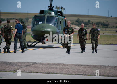 Civil Air Patrol Capt. Miguel Acevedo, Cheyenne nel lato sinistro gruppo, conduce il successivo gruppo di cadetti, a Camp Guernsey, Wyo., a volare a UH1 da F.E. Warren Air Force Base, basato in Cheyenne Wyo. "Huey' capo equipaggio spiega come inserire il velivolo. Di ritorno dal loro volo, sono Civil Air Patrol cadetti, Cadet Senior Airman Chris Garcia di Medical Lago, nello Stato di Washington, sinistra e Cadet 1Lt. Ezechiele House, di Cheyenne Wyo.; e Cadet Airman Zack Johnston, di Cody, Wyo. (Civil Air Patrol Cadet 2 Lt. Jonathan Barella) Foto Stock